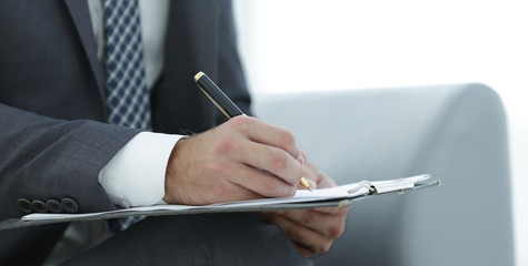 Businessman signs a contract. Holding pen in hand.