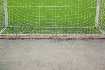 sport concept of synthetic football or soccer field space with gates and grass background texture...