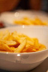 Pile of piping hot and crispy delicious French fries or chips.