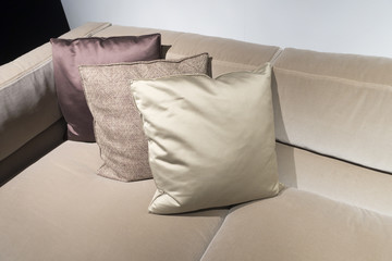 light brown coach with 3 pillows at one corner