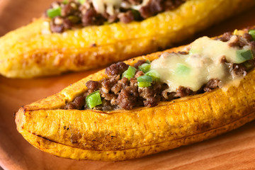 Baked ripe plantain stuffed with mincemeat, olive, green bell pepper, onion, traditional dish in...