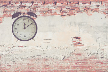 old fashioned alarm clock  on concrete bricks for background, filtered tones