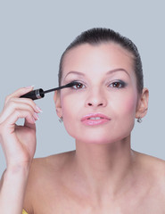 Close-up of a beautiful woman with a brush for mascara