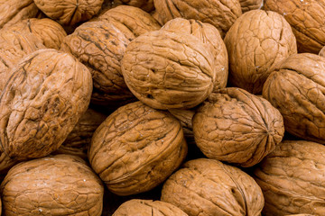 Closed walnuts on wooden background