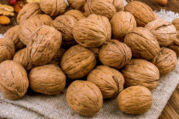 Closed walnuts on wooden background