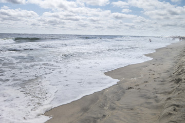 sunny day sky with fluffy clouds beach shore line waves and sand