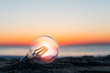 Lightbulb on the beach during sunrise