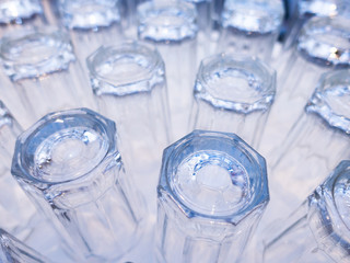 clean rows of upside down drinking glasses empty