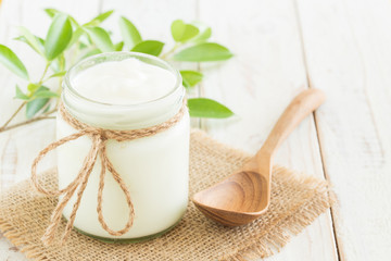 Yogurt in glass bottles on white wooden table Healthy food concept