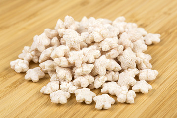 Piles of pale whole grain children's puffed cereal snack