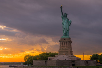Fototapeta na wymiar Sunset View of Statue of Liberty in New York Harbor