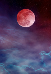 Red moon or blood moon with many stars and clouds on colorful sky.