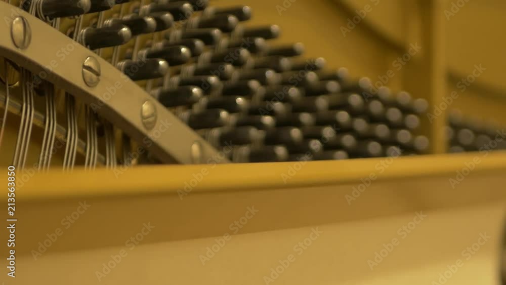 Poster view inside of a piano. sliding close up shot of the strings and the inside parts of a piano.