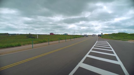 Trucks drive by on small road on cloudy day