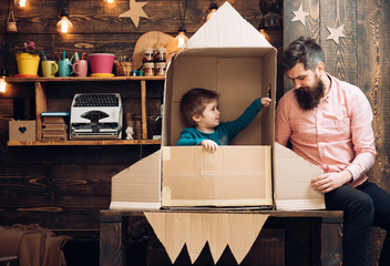 Father and small boy in paper rocket. father and son play with rocket and dreaming about future...