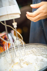 whipped cream cooking process.woman mixing Fresh cream for making whipped cream or desserts and bekery.woman making whipped cream and show process with stand or hand mixer.