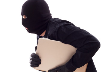 maskierter klaut Daten auf einem Laptop