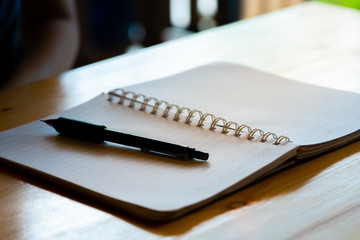 female hand with pencil writing on notebook at coffee shop.woman working by hand writing on letter paper on the wooden desk.woman hand writing.