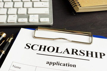 Scholarship application and money for education on a table.