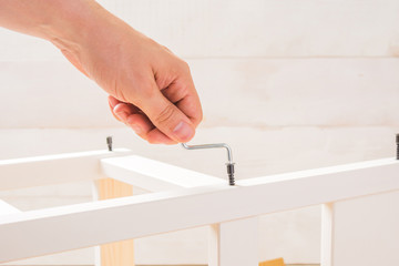 Male hand hold a furniture screwdriver on white backgorund