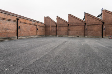 Fototapeta premium Brick wall and asphalt parking space