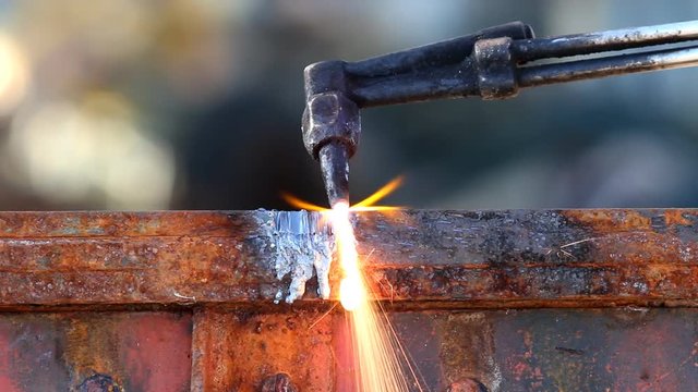 A worker cutting steel using metal torch