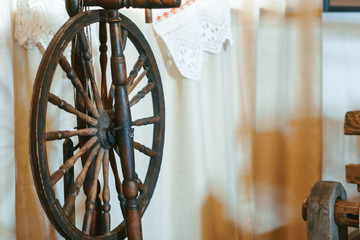 A spinning wheel with yarn baskets and old chair