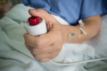 Patient hand pressing emergency nurse call button