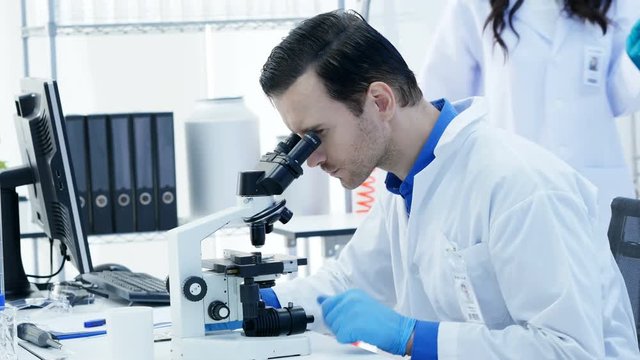 Scientists or chemists using microscopes and other technologies. male Scientists working in a laboratory. 4K Resolution.