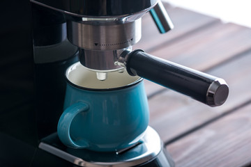 Preparation of espresso. Black coffee machine on the table. Professional coffee brewing at home