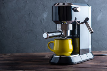 Preparation of espresso. Black coffee machine on the table. Professional coffee brewing