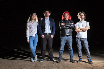 Group of friends having fun together outdoor in a night and light behind