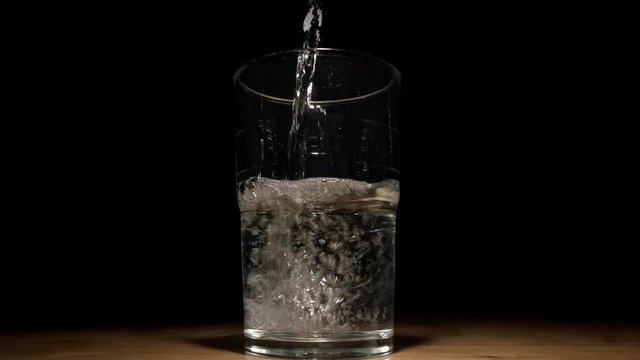 This video shows a drinking glass filling up with water in front of a truly black background for OLED displays.