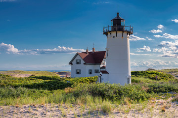 Fototapeta na wymiar Lighthouse Point on beach dunes, Race Point Light Lighthouse in Cape Code, New England, Massachusetts, USA.