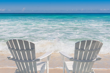 Beach chairs on sandy beach and turquoise sea.  Summer vacation and travel concept.  