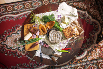 Rural food, cooked on organic farms, according to traditional recipes. Vegetables from the garden, cheese, meat and sausages spread out on a wooden table.