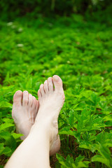Young adult feet resting on the grass