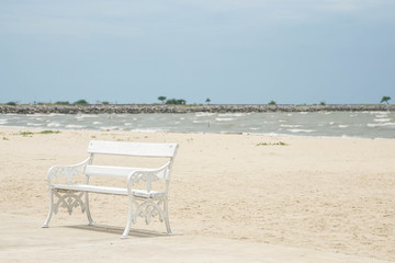 Fototapeta na wymiar peace concept of white wooden bench for seat at seaside on the beach