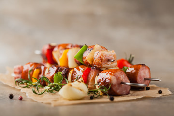Grilled skewers with sausage, bacon and vegetables.