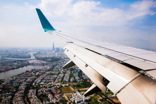 Vietnam cityscape view from airplane window,wing of plane over vietnam city.