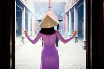 Young Vietnam woman wearing Ao Dai culture traditional at old temple at Ho Chi Minh in Vietnam,vintage style,travel and relaxing concept.
