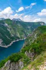 A picturesque turquoise lake can be seen from the top of a high mountain.