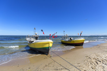 Fishing boats by the sandy beach on the Baltic Sea on a sunny day, Sopot, Poland.
