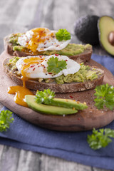 Avocado egg bread on brown board blue material and broan wodden background