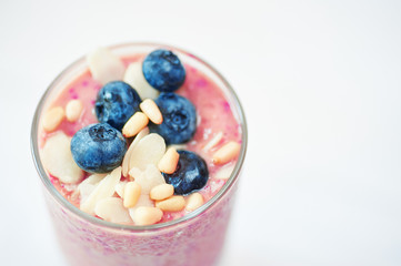 Glass of pink fruit smoothies milkshake or cocktail on white background, breakfast vegan, with a place for your text, concept of raw food