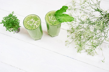 Blended green smoothie with ingredients or cocktail on white background, breakfast vegan with a place for your text, concept of raw food detox