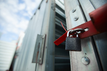 Close-up of closed cargo container on lock, sealed container in warehouse area © pressmaster
