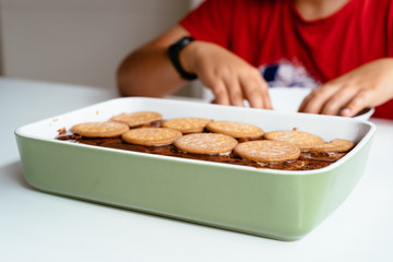 Close up of child preparing homemade chocolate cake