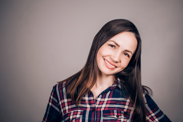 Fototapeta premium Happy joyful woman on grey background looking at camera with smile
