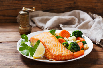 plate of baked salmon steak with vegetables